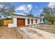 Charming single story home with a new gray roof, red door, and a well-maintained front yard at 8930 94Th Ave, Seminole, FL 33777