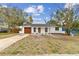 Charming single-story home with a fresh white exterior, a brown garage door, and a well-maintained front yard at 8930 94Th Ave, Seminole, FL 33777