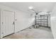 Garage has bare concrete floors, white-painted walls, and door to outside at 8930 94Th Ave, Seminole, FL 33777