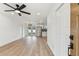 Bright living room features ceiling fan, wood-look floors, and a stainless steel refrigerator in the kitchen at 8930 94Th Ave, Seminole, FL 33777