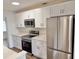 Bright kitchen features updated stainless appliances, white cabinets, and sleek countertops at 907 Lakewood Ave, Tampa, FL 33613