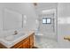 Bright white bathroom featuring tile floors, updated sink, toilet, and shower at 9811 Memorial Hwy, Tampa, FL 33615