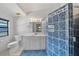 Bathroom boasts a single sink vanity, and walk-in shower with blue tile, and natural light at 9811 Memorial Hwy, Tampa, FL 33615