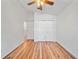 Neutral bedroom features wood floors, a ceiling fan, a double door closet, and white doors at 9811 Memorial Hwy, Tampa, FL 33615