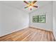This bright bedroom includes wood floors, a ceiling fan, and a large window offering views to the outdoors at 9811 Memorial Hwy, Tampa, FL 33615