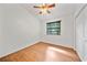 Bedroom features wood floors, a ceiling fan, and a window view of nature at 9811 Memorial Hwy, Tampa, FL 33615