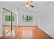 This bedroom includes hardwood floors, a ceiling fan, and a sliding mirror closet at 9811 Memorial Hwy, Tampa, FL 33615