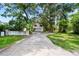Exterior view of a two-story house with a garage and a spacious driveway surrounded by trees at 9811 Memorial Hwy, Tampa, FL 33615