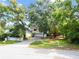 Two-story home with a garage and long driveway, surrounded by a mix of trees and greenery at 9811 Memorial Hwy, Tampa, FL 33615
