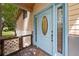 Charming blue front door featuring sidelights and an oval window, complemented by a decorative lattice gate at 9811 Memorial Hwy, Tampa, FL 33615