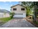 Two-story home showcasing a two-car garage with a long driveway and well-maintained landscaping at 9811 Memorial Hwy, Tampa, FL 33615
