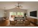 Bright living room boasts vaulted ceilings, a ceiling fan, and access to a balcony with sliding doors at 9811 Memorial Hwy, Tampa, FL 33615