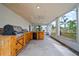 Screened-in lanai with a wooden outdoor kitchen with sink and grill at 9811 Memorial Hwy, Tampa, FL 33615