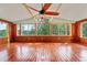 Screened-in porch boasting natural light, wood paneling, and a ceiling fan at 9811 Memorial Hwy, Tampa, FL 33615
