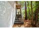 Outdoor staircase with a lattice gate, leading to the entrance, set amongst trees and lush greenery at 9811 Memorial Hwy, Tampa, FL 33615