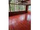 Spacious sunroom with hardwood floors, wood paneling, multiple windows, and a ceiling fan at 9811 Memorial Hwy, Tampa, FL 33615