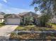 Beautiful home features a lush lawn, lovely landscaping, and a two-car garage at 10221 Ashley Oaks Dr, Riverview, FL 33578