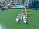 An aerial view displaying a pool area, covered parking, boat docks, and waterfront at 10355 Paradise Blvd # 614, Treasure Island, FL 33706