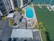 Aerial view showcasing the building, pool area, boat docks, and waterfront at 10355 Paradise Blvd # 614, Treasure Island, FL 33706