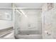 An all-white bathroom featuring a bathtub with patterned glass door at 10355 Paradise Blvd # 614, Treasure Island, FL 33706