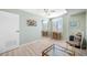 Bedroom with pale green walls, light wood floor, ceiling fan and desk area by the window at 10355 Paradise Blvd # 614, Treasure Island, FL 33706