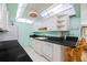 Bright kitchen featuring white cabinetry and black countertops, with an open feel to the living area at 10355 Paradise Blvd # 614, Treasure Island, FL 33706