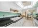 This kitchen features tile floors, white cabinets, black countertops, and access to the dining and living areas at 10355 Paradise Blvd # 614, Treasure Island, FL 33706
