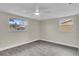 Bright and airy bedroom with gray plank floors and two windows at 10837 Inglewood Ave, Port Richey, FL 34668