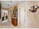 Hallway with neutral paint and carpet, plus a mirrored decor cabinet with decorative iron and wall sconces at 123 12Th E St, Tierra Verde, FL 33715