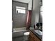 Bathroom featuring a shower-tub combo with a grey tile surround and granite vanity at 1556 N River Cir, Tarpon Springs, FL 34689