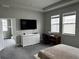 Bright bedroom with a built-in desk, TV, dresser, and adjoining sun room at 1556 N River Cir, Tarpon Springs, FL 34689