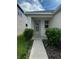 Inviting front entrance with a decorative glass door, small garden and a concrete walkway at 1556 N River Cir, Tarpon Springs, FL 34689