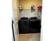 Laundry room with modern black washer and dryer units and overhead storage space at 1556 N River Cir, Tarpon Springs, FL 34689