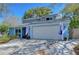 Lovely light blue home with a two-car garage, neat landscaping, and patriotic flags at 15927 Crying Wind Dr, Tampa, FL 33624