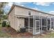 Home exterior featuring a screened-in patio, neutral siding, and manicured landscaping at 15928 Fishhawk View Dr, Lithia, FL 33547