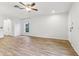 Bright and open living room featuring hardwood floors, ceiling fan, and a large window at 15928 Fishhawk View Dr, Lithia, FL 33547