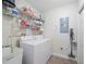 Efficient laundry room with storage shelves, utility sink, washer, and dryer for easy chore management at 17735 Gulf Blvd # 204, Redington Shores, FL 33708