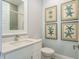 Clean bathroom featuring a white vanity with quartz countertop, a toilet, and coastal themed decorations at 188 Brightwater Dr # 2, Clearwater Beach, FL 33767