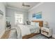 Stylishly designed bedroom with a ceiling fan, large window and hardwood flooring at 188 Brightwater Dr # 2, Clearwater Beach, FL 33767