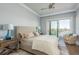 Calm primary bedroom with water views from the balcony, a ceiling fan, and calming light-blue walls at 188 Brightwater Dr # 2, Clearwater Beach, FL 33767