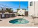 Community hot tub with lush landscaping, outdoor grills, and table with seating, perfect for relaxation at 188 Brightwater Dr # 2, Clearwater Beach, FL 33767