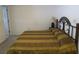 Bedroom with a patterned brown and tan bedspread, and dark wrought iron headboard at 1950 59Th N Ave # 212, St Petersburg, FL 33714