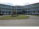 Attractive condo building with a central courtyard, manicured lawn, and a prominent American flag at 1950 59Th N Ave # 212, St Petersburg, FL 33714