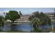 Exterior view of condo complex overlooking a pond with fountain, palm trees, and green grass at 1950 59Th N Ave # 212, St Petersburg, FL 33714