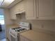 Bright kitchen featuring white cabinets, a gas range, and neutral countertops at 1950 59Th N Ave # 212, St Petersburg, FL 33714