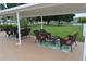 Outdoor patio seating area with wicker furniture overlooks a manicured lawn and peaceful pond at 1950 59Th N Ave # 212, St Petersburg, FL 33714