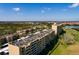 Aerial view of beige condo complex, showcasing the manicured landscaping and serene lake at 2617 Cove Cay Dr # 710, Clearwater, FL 33760