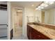Bathroom with granite counters, wooden cabinets and tile floors near shower and bath at 2617 Cove Cay Dr # 710, Clearwater, FL 33760