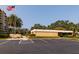 A wide shot showing the exterior of the community clubhouse with convenient parking spaces and the American flag at 2617 Cove Cay Dr # 710, Clearwater, FL 33760