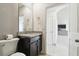 Cozy bathroom featuring a dark vanity, granite countertop, and a framed mirror at 2748 Garden Plum Pl, Odessa, FL 33556